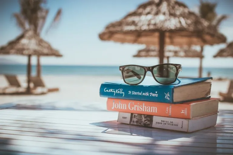 Gafas sobre pila de libros en la playa